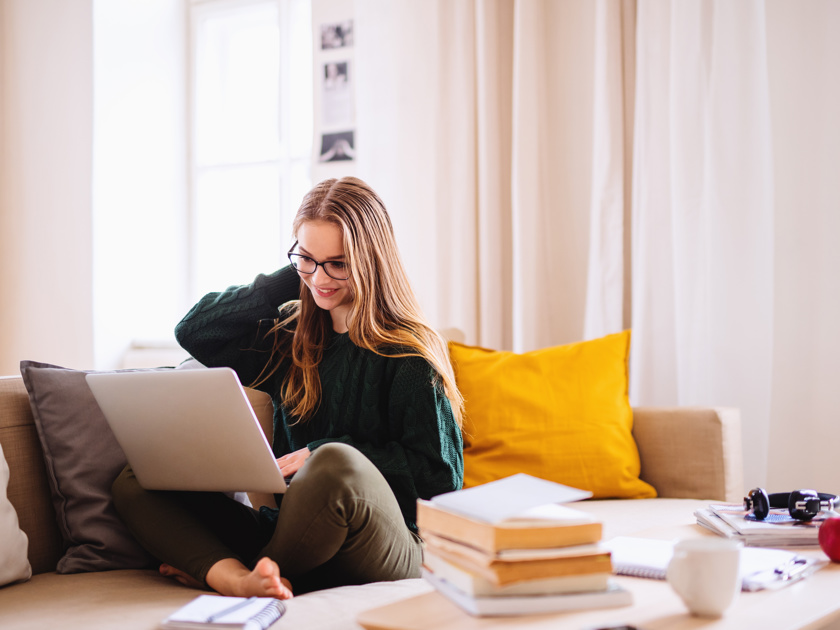 Woman Looking At Her Computer On A Couch